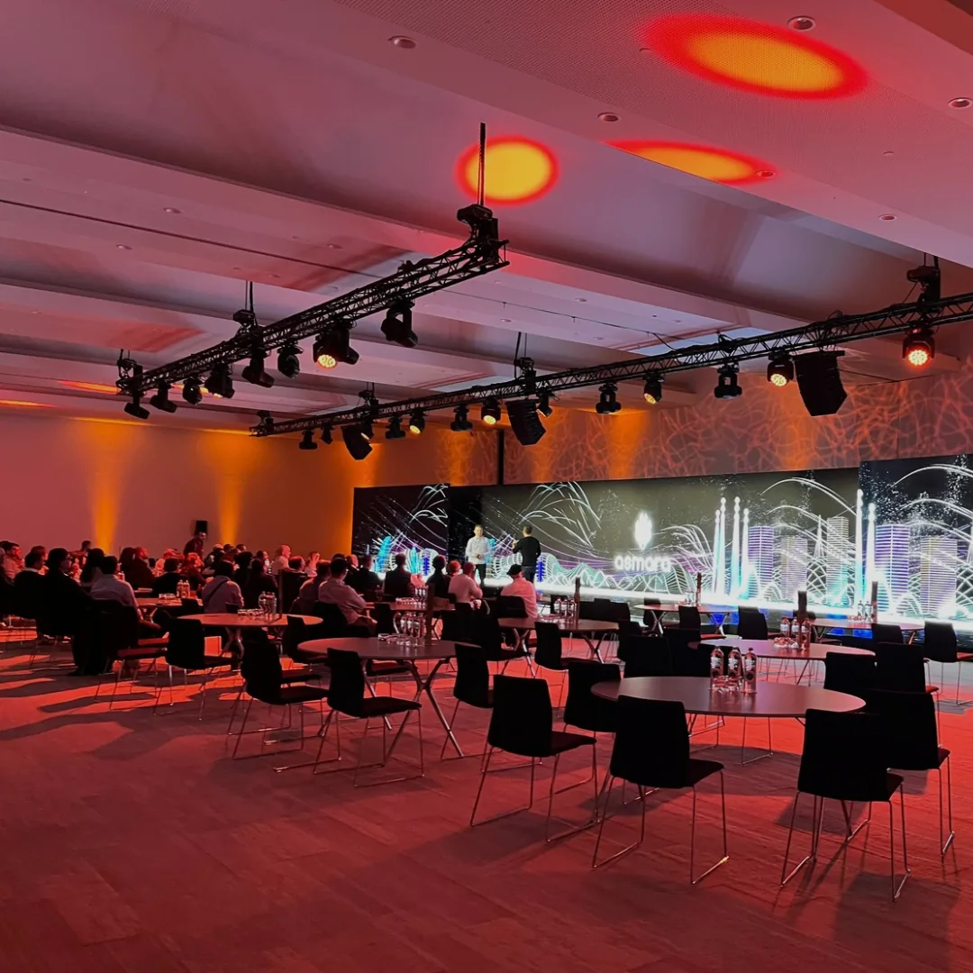 Cena de gala de Asmara en un salón de hotel, con estructura de truss, focos y una pantalla de LED al fondo.