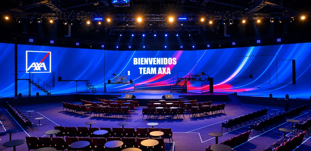 Recinto con pantalla curva de LED gigante que da la bienvenida al Team AXA, en azul y rosa.